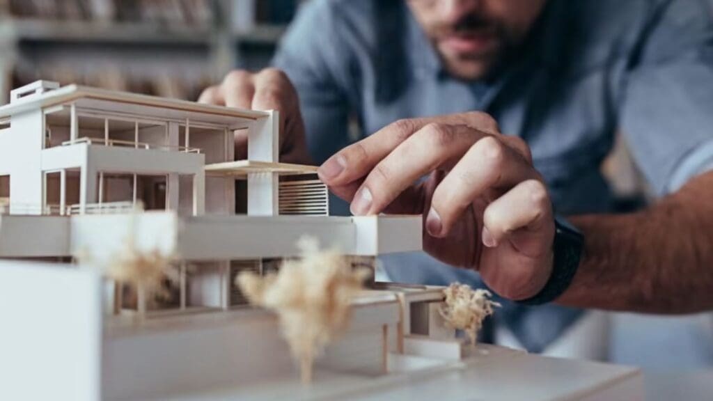 Arquitecto técnico de España armando una maqueta de una vivienda moderna post-pandemia