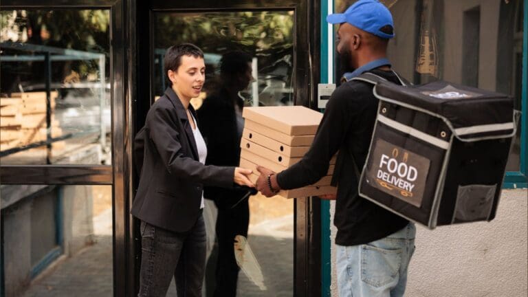 Mujer recibiendo domicilio de comida para la oficina y sus empleados en España