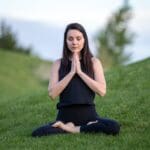 Mujer realizando prácticas de respiración consciente en surrender to the breath.