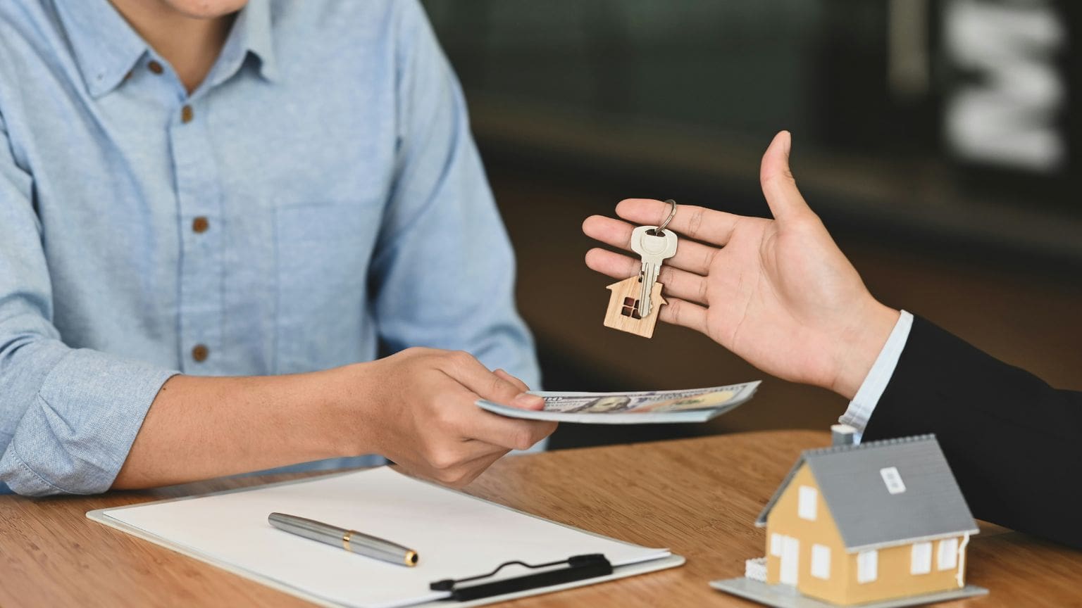 Hombre entregando dinero y recibiendo llaves de su nueva vivienda en España