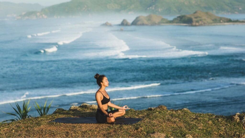 Mujer practicando meditación al aire libre. Promoviendo el bienestar emocional y la reducción del estrés a través de la formación en meditación y mindfulness.