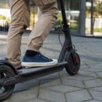 Turistas utilizando patinetes eléctricos en Mallorca, promoviendo la movilidad sostenible y el alquiler de vehículos ecológicos en la ciudad.