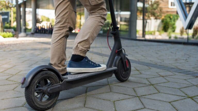 Turistas utilizando patinetes eléctricos en Mallorca, promoviendo la movilidad sostenible y el alquiler de vehículos ecológicos en la ciudad.