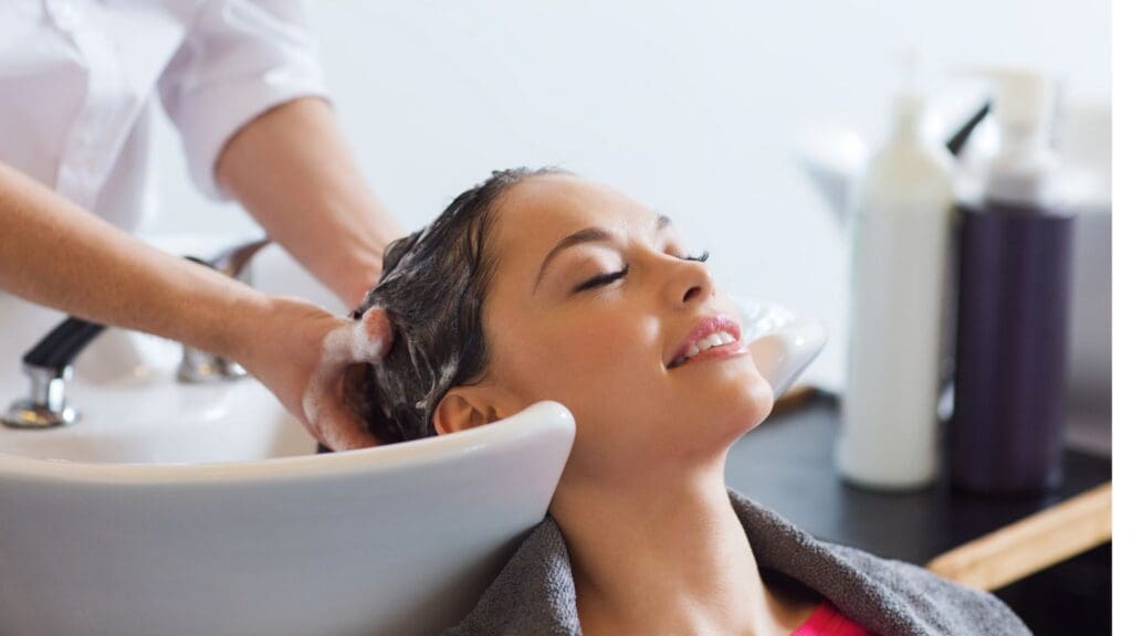 Estilista profesional cuida el cabello de una mujer para mantenerlo sano y con brillo.