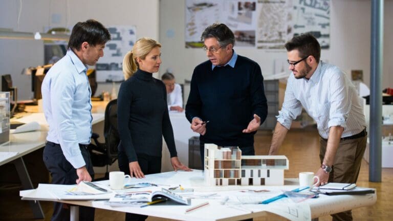 Equipo de arquitectos revisando planos de diseño e interiorismo para un proyecto de reforma integral.