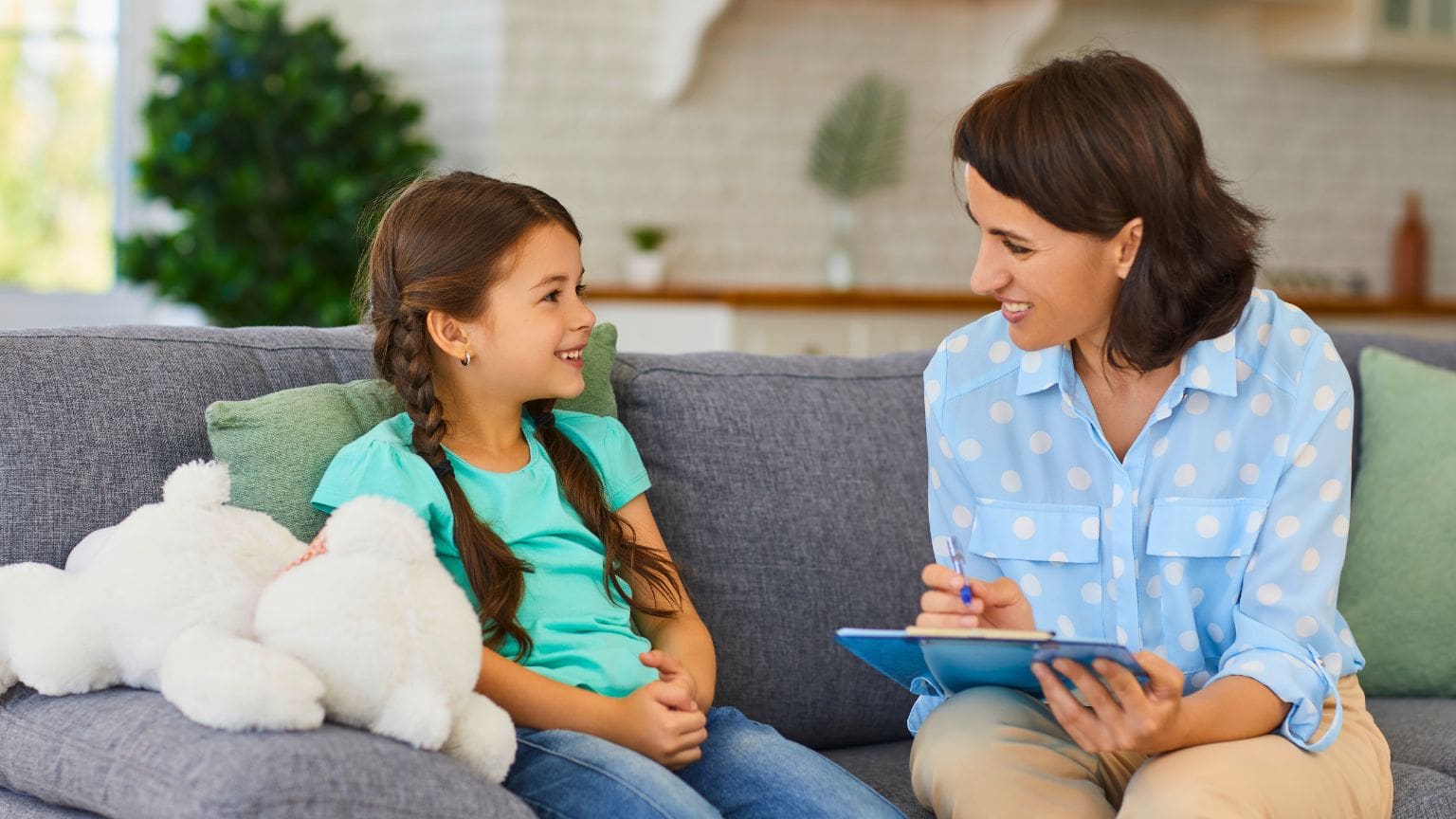 Psicóloga especializada en terapia infantil ayudando a un niño a expresar sus emociones durante una sesión de psicoterapia en Cerdanyola.