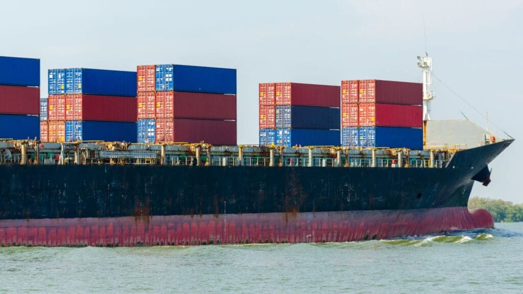 Barco de carga transportando contenedores en el mar, representando el transporte internacional.