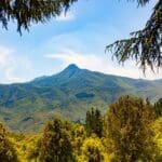 Vista de una casa rural en el Parque Natural del Montseny rodeada de naturaleza y montañas, ideal para una escapada tranquila en un entorno protegido