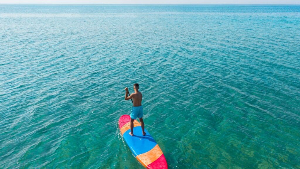 Persona disfrutando de diversas actividades acuáticas como paddle surf en Ibiza.