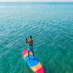 Persona disfrutando de diversas actividades acuáticas como paddle surf en Ibiza.