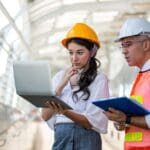 Equipo de ingenieros trabajando en la gestión de un proyecto técnico, revisando planos y asegurando el cumplimiento normativo.