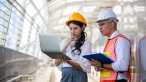 Equipo de ingenieros trabajando en la gestión de un proyecto técnico, revisando planos y asegurando el cumplimiento normativo.