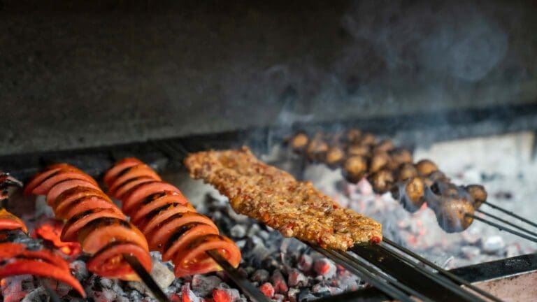 Plato de chuletón a la brasa servido con guarnición, acompañado de vino en un restaurante asador tradicional.