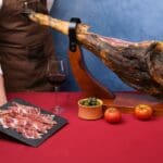 Cortador de jamón profesional en boda realizando corte de jamón ibérico para invitados.