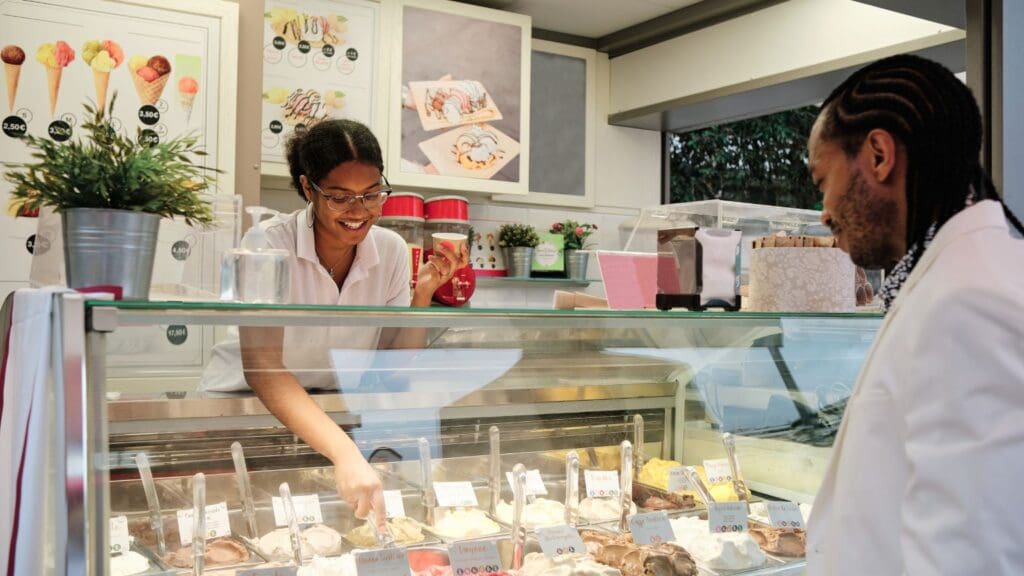 Franquicia de helados low cost con clientes disfrutando de helados y gofres en un local moderno