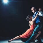 Pareja bailando en una academia de baile en Hospitalet, disfrutando de una clase de salsa y bachata con ambiente acogedor y profesional.