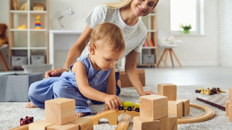 Un bebé jugando con bloques de madera educativos en un entorno seguro. Juguetes sostenibles diseñados para el desarrollo y la diversión infantil.