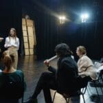 Group of people participating in an acting class in Barcelona, expressing creativity and building communication skills through theater activities.