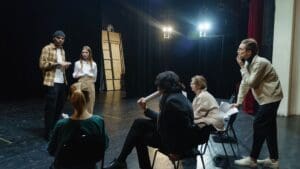 Group of people participating in an acting class in Barcelona, expressing creativity and building communication skills through theater activities.