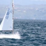 Persona navegando en un velero adaptado con tecnología inclusiva, disfrutando de la experiencia en el mar, con un enfoque en accesibilidad y autonomía.