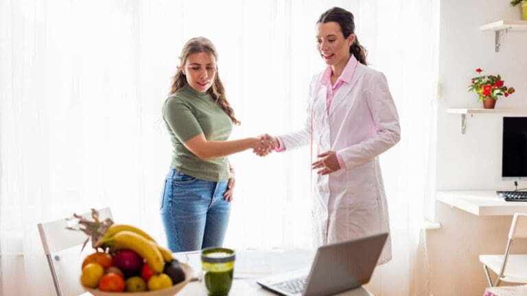 Persona preparando una comida saludable con frutas y verduras frescas, representando equilibrio y bienestar a través de la nutrición personalizada.