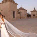 Pareja de novios posando al atardecer, capturando un momento romántico y creativo durante su sesión de fotos de boda.