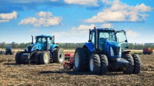 Máquina agrícola moderna cortando gavillas de ajo seco en un campo, destacando la mecanización y eficiencia en el sector agrícola.