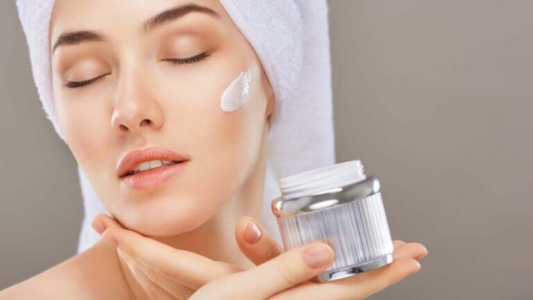 Mujer aplicando crema facial como parte de su rutina de belleza para una piel saludable y luminosa