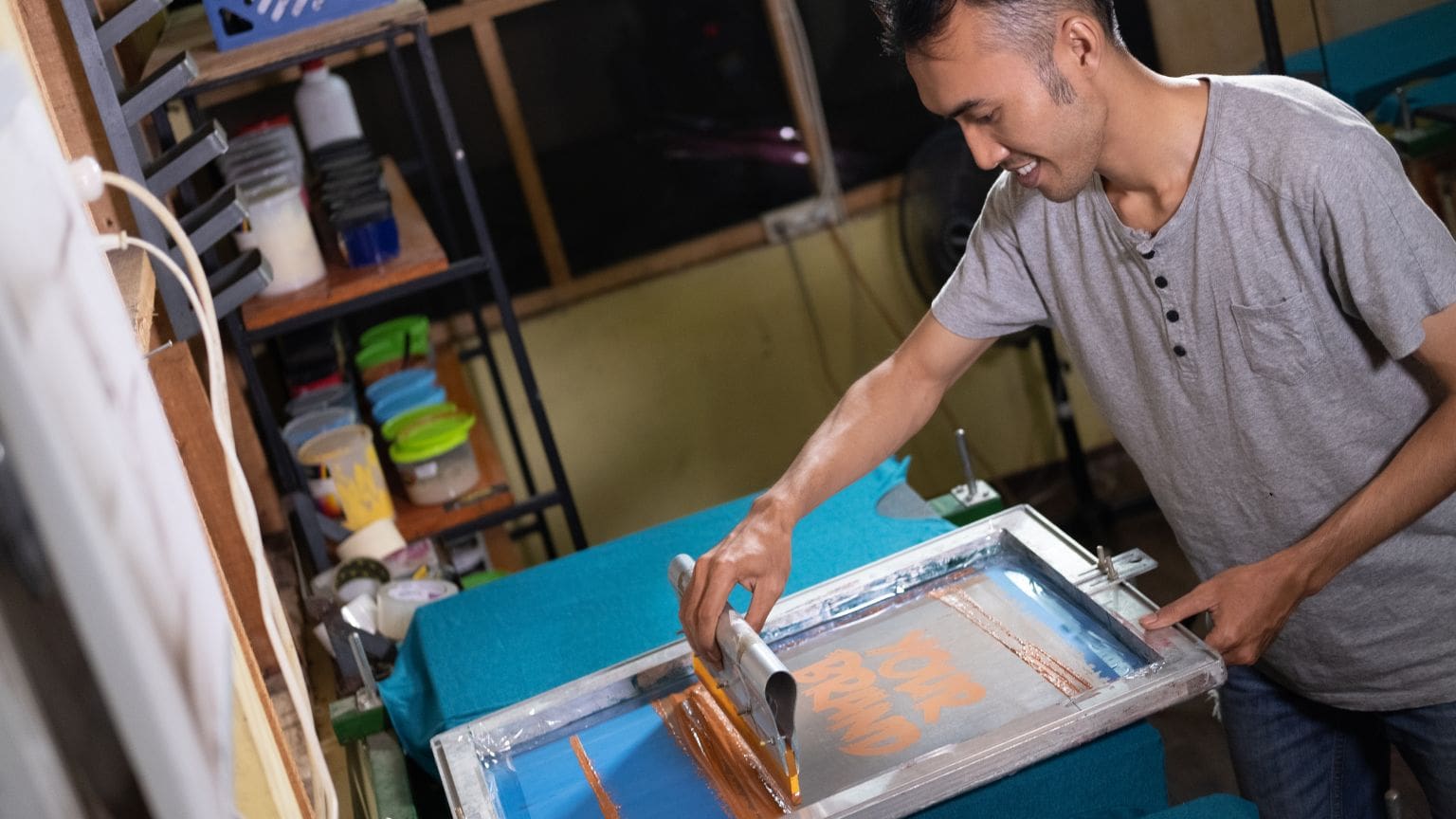 Persona personalizando una camiseta con serigrafía en un taller de diseño. Ejemplo de técnicas de personalización de ropa urbana con vinilo textil y bordado.