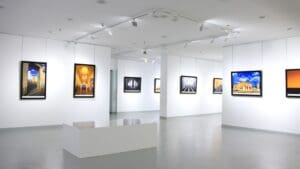 Exposición de arte contemporáneo con obras exclusivas y visitantes en una galería moderna.