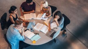 Grupo de estudiantes en formación en hostelería y turismo, aprendiendo sobre dirección hotelera y gestión de restaurantes en un aula profesional.