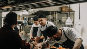 Equipo profesional de hostelería ofreciendo un servicio de alta calidad en un restaurante elegante.