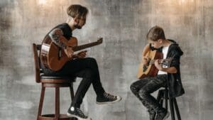 Músico tomando una masterclass en línea con profesor experto, aprendiendo teoría musical y composición desde casa.