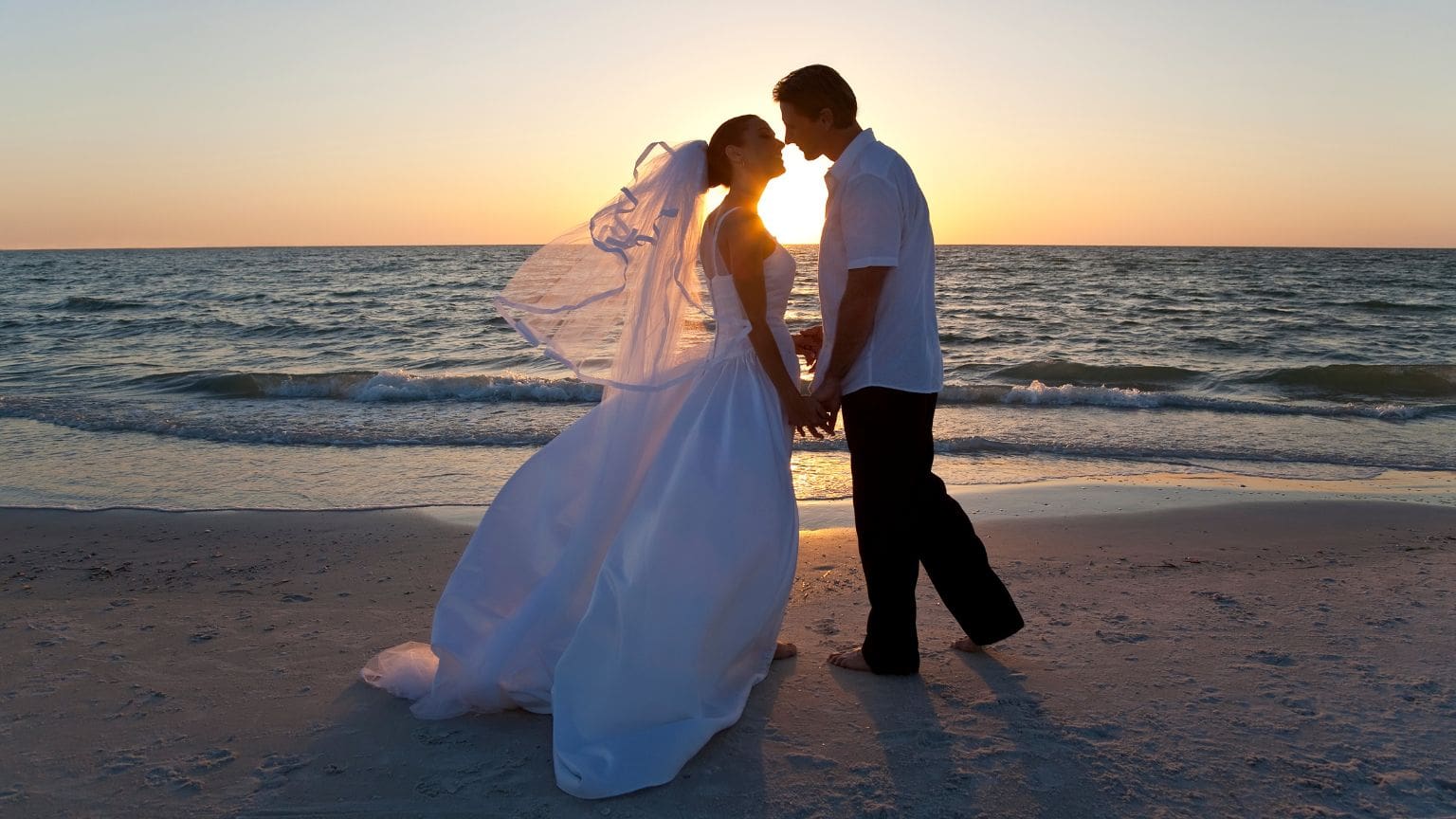 Pareja en una boda elegante capturada al atardecer con estilo editorial y composición artística, reflejando las tendencias actuales en fotografía de bodas.