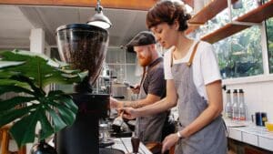 Alumno en curso de barista preparando café espresso con máquina profesional
