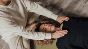 Sesión de fisioterapia holística en un ambiente luminoso y tranquilo, terapeuta trabajando la energía corporal para promover el bienestar integral.
