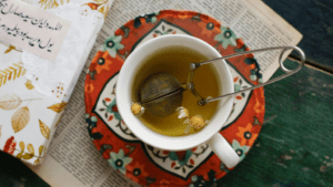 Taza de té caliente sobre una mesa, rodeada de hierbas naturales, transmitiendo calma y bienestar.