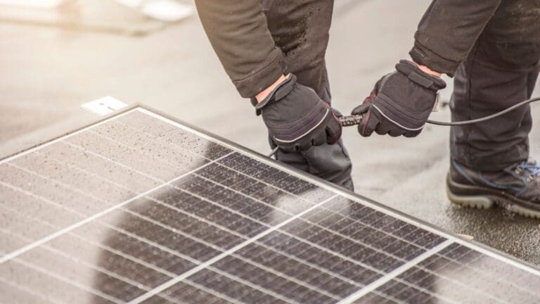 Técnico instalando panel solar en una vivienda en España.