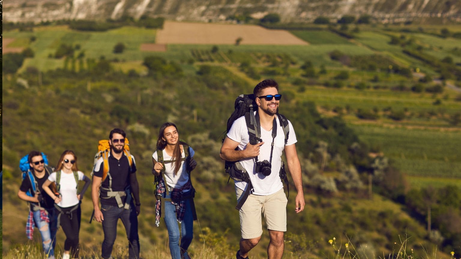 Grupo de personas disfrutando de un tour rural guiado en un entorno natural con casas tradicionales y guía local, representando el turismo rural en España.