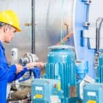 Técnico realizando mantenimiento a una llenadora de bidones en planta industrial