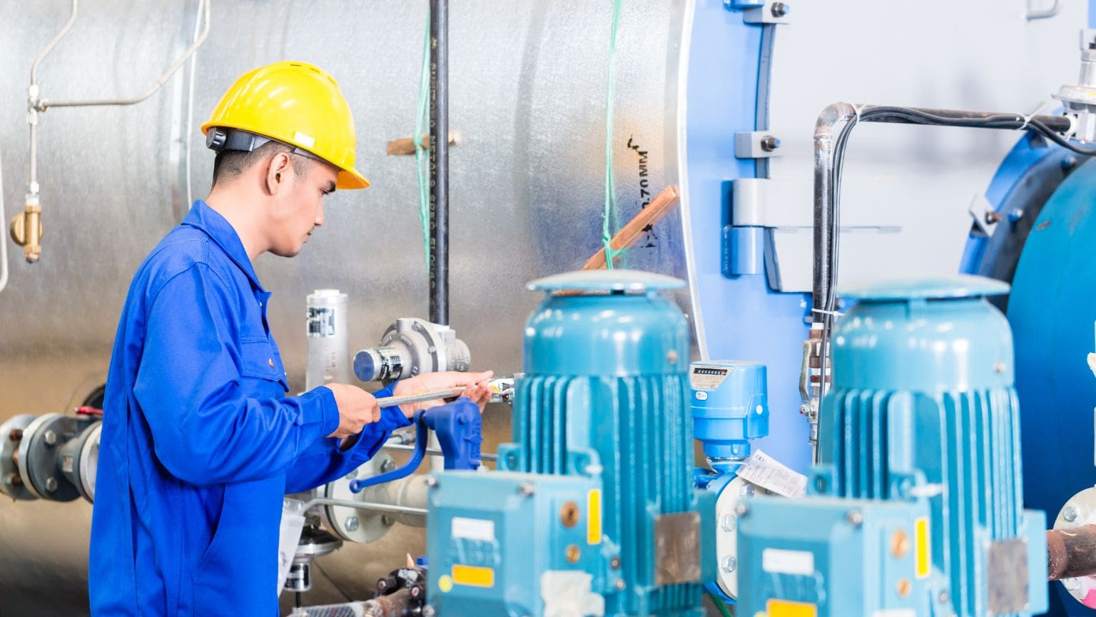 Técnico realizando mantenimiento a una llenadora de bidones en planta industrial