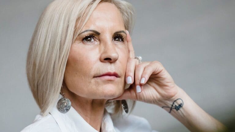Mujer de mediana edad en proceso de sanación emocional durante la menopausia tras experiencias de trauma infantil.
