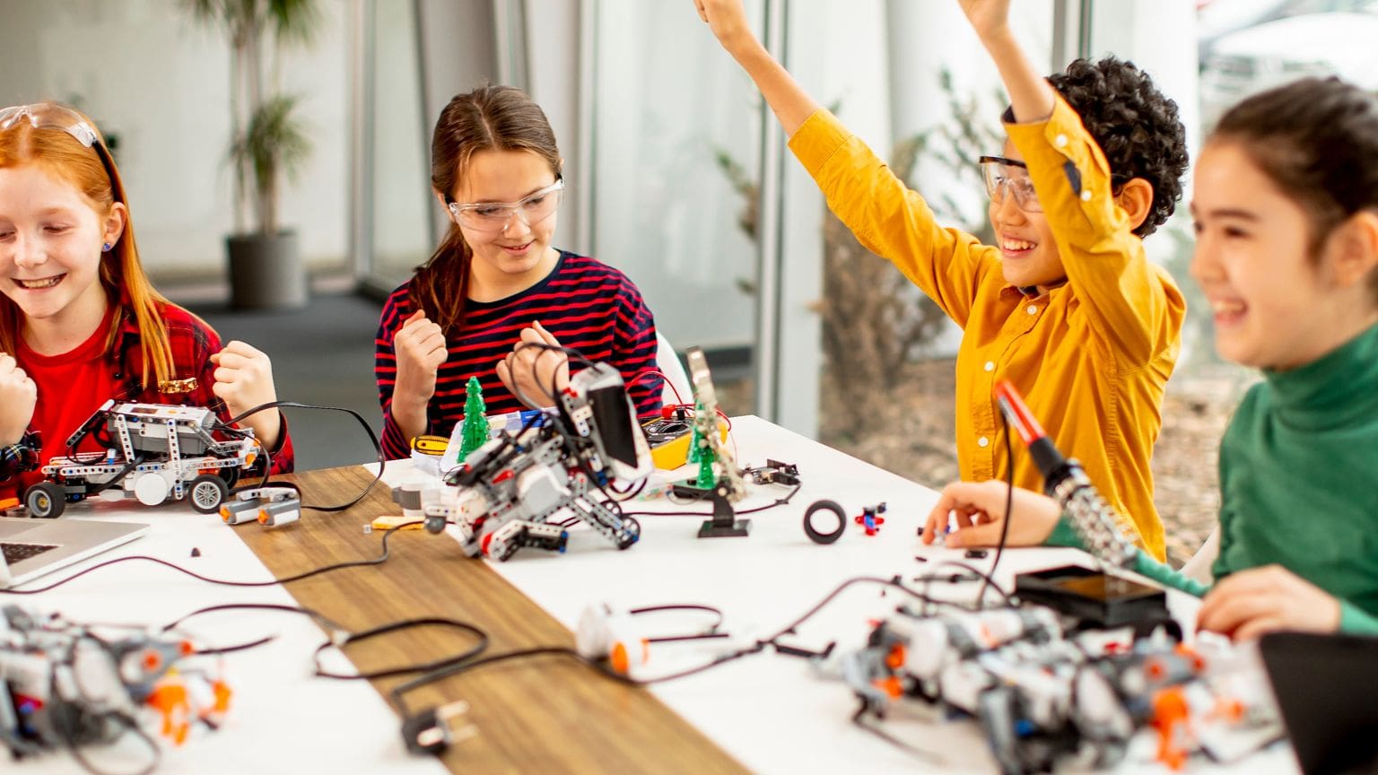 Niños en clase de robótica desarrollando habilidades emocionales y tecnológicas.