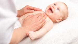 Bebé recibiendo fisioterapia pediátrica en casa junto a su madre en un entorno familiar tranquilo
