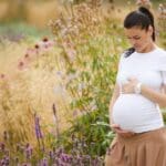 Mujer embarazada posando en un entorno natural durante una sesión de fotos de embarazo profesional en Murcia
