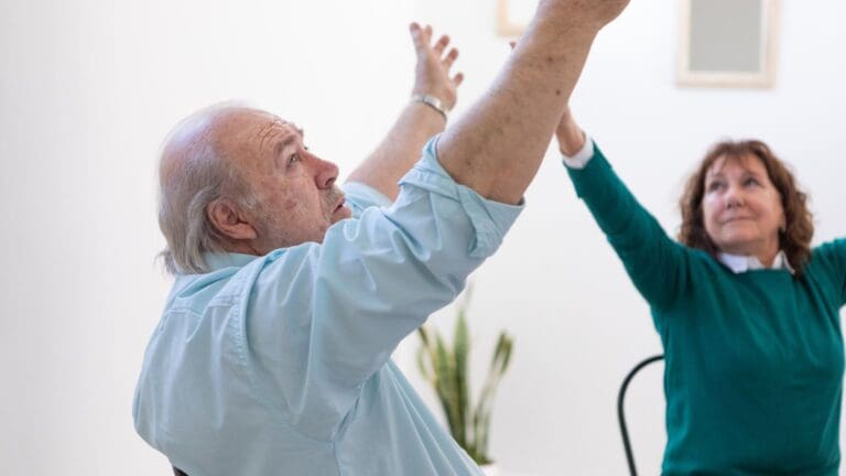 Personas realizando ejercicios de estimulación cognitiva en casa para mantener el cerebro joven y activo, fortaleciendo la memoria y la concentración.