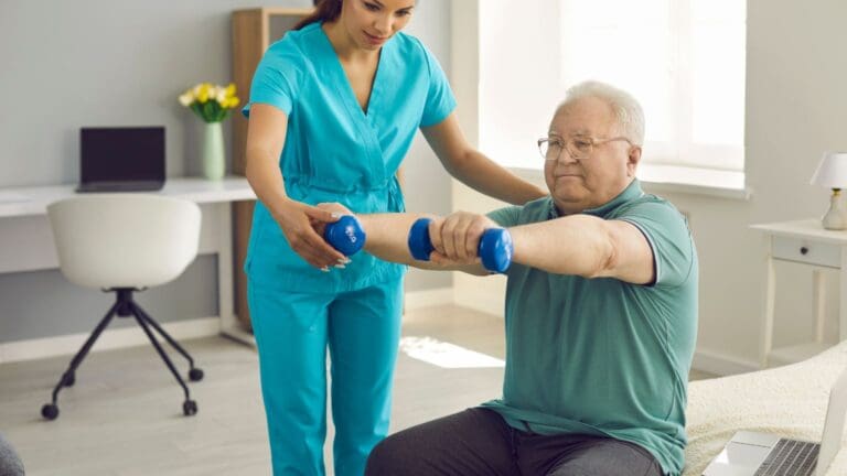 Persona mayor realizando ejercicios de fisioterapia geriátrica con asistencia profesional para mejorar movilidad y prevenir caídas.