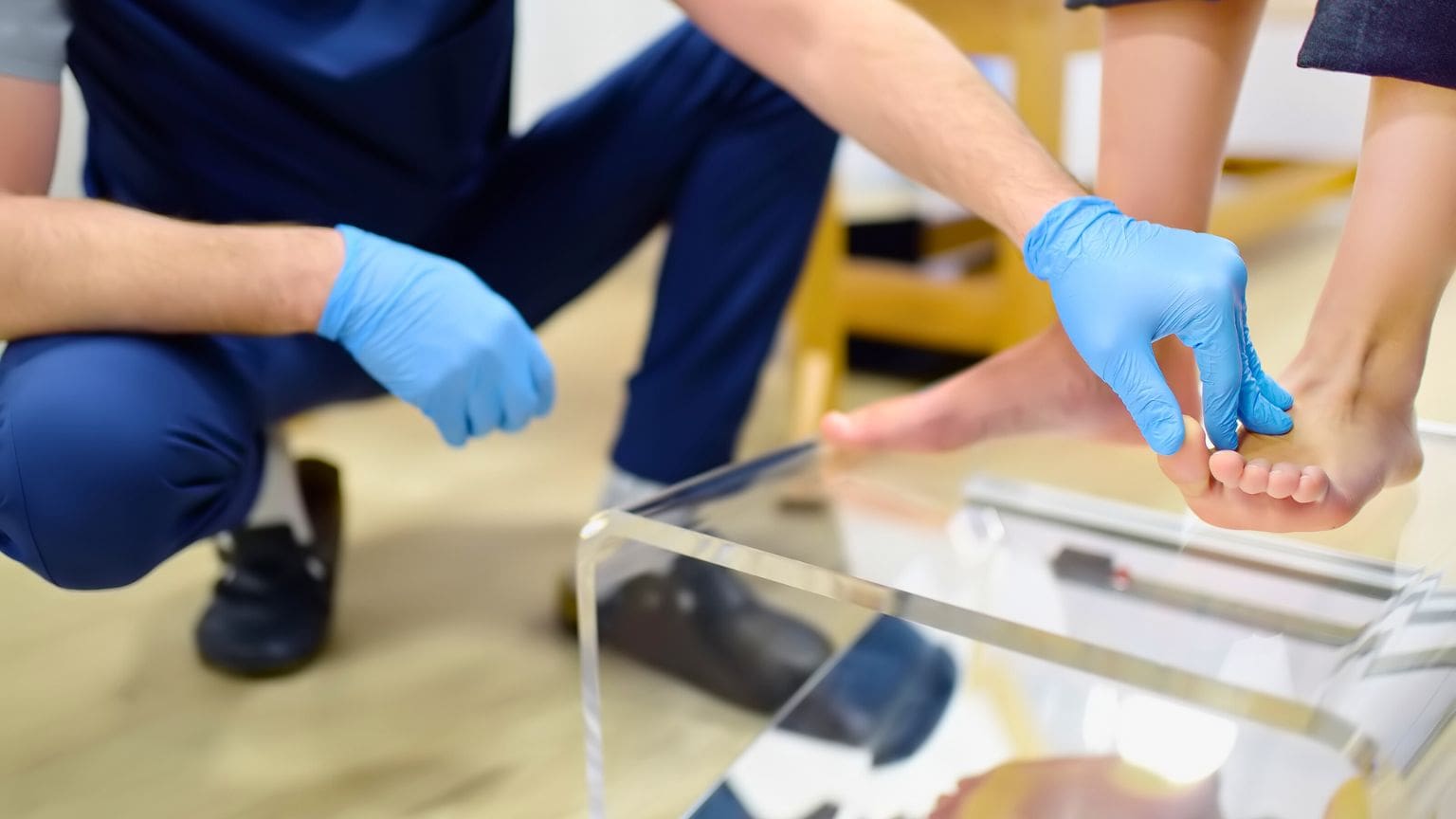 Podólogo realizando un estudio de la pisada para diagnosticar y corregir pies planos con plantillas ortopédicas personalizadas.