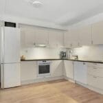 Cocina moderna y funcional con distribución en L, muebles integrados y luz natural, ejemplo de reforma inteligente para ganar espacio sin ampliar metros en una vivienda en Sevilla.