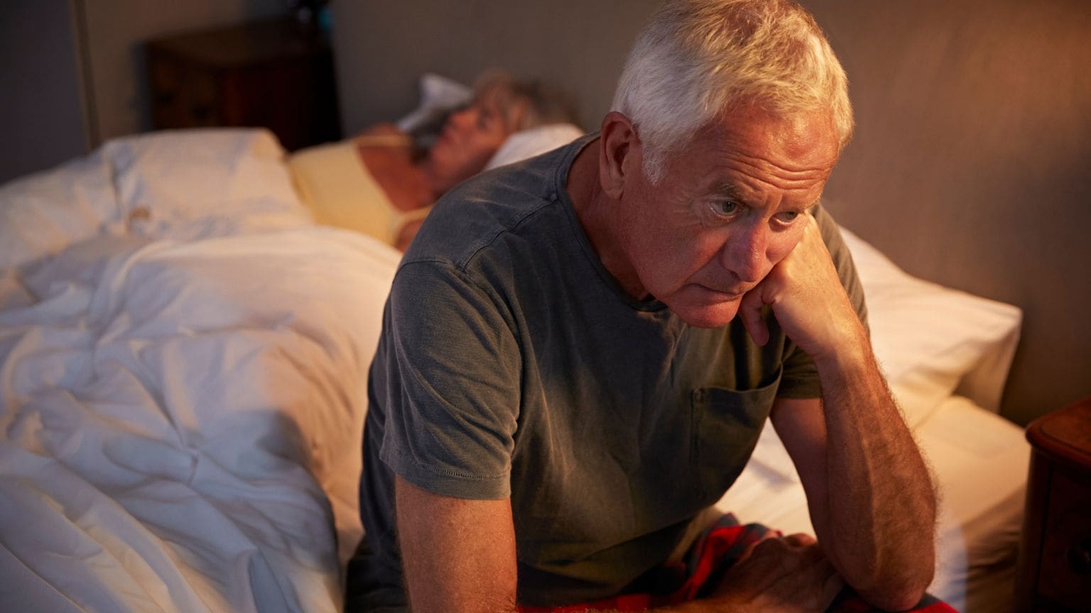 Persona con insomnio acostada en la cama, representando los trastornos del sueño y la dificultad para dormir mejor